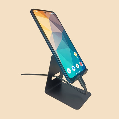 Mobile phone placed on the stand with a charging cable attached